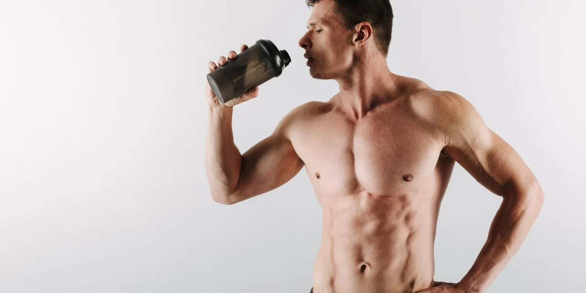 man drinking whey protein in bottle