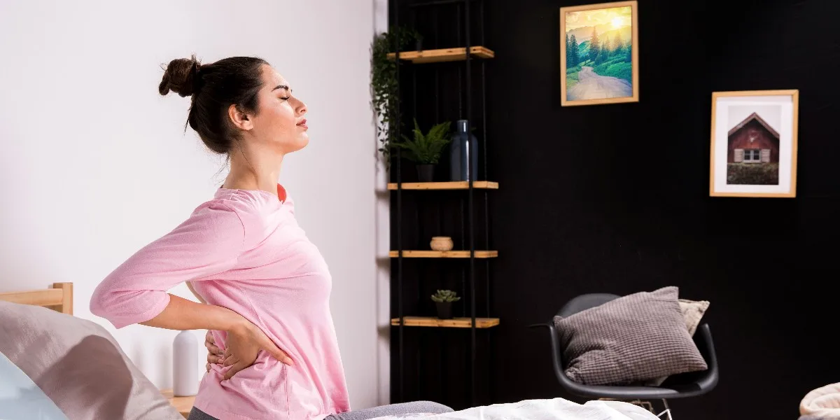 fitness woman waking up in the morning with back pain