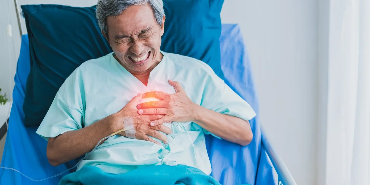 Senior Asian man experiencing chest discomfort, indicative of possible heart issues or heartburn