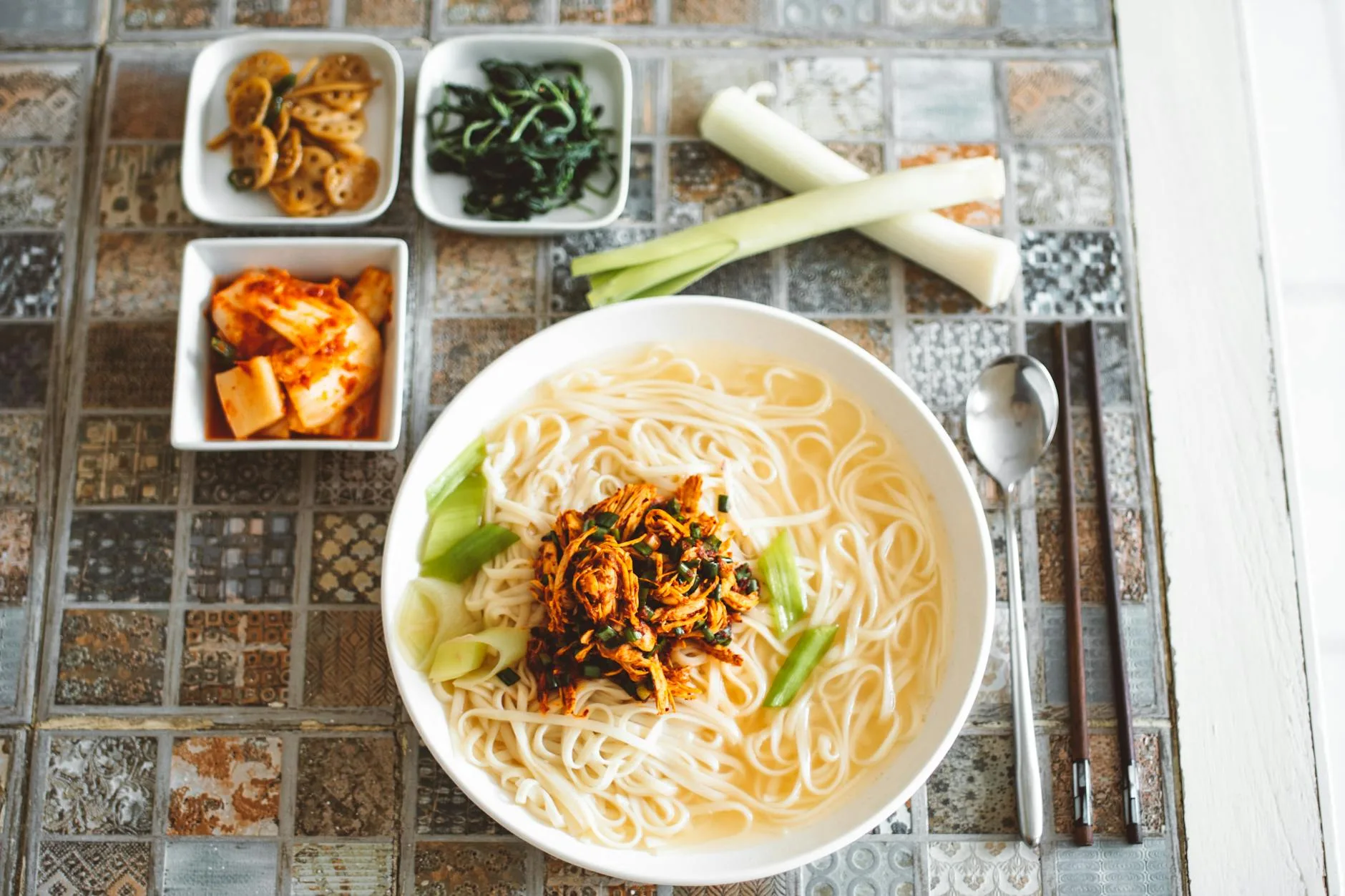 a bowl of noodles and side dishes